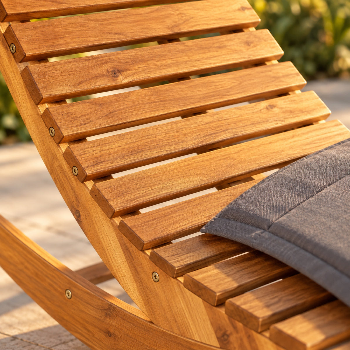 Chaise longue à bascule en acacia massif, coussin gris, gros plan sur la matière