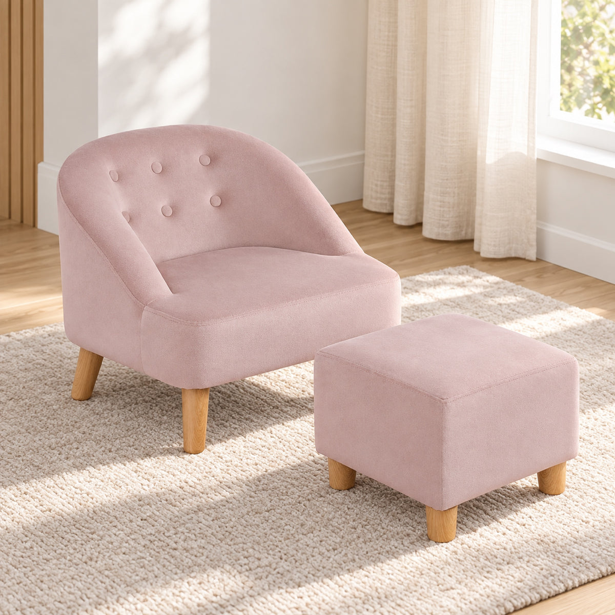 Fauteuil enfant en velours rose avec pouf assorti, mis en situation