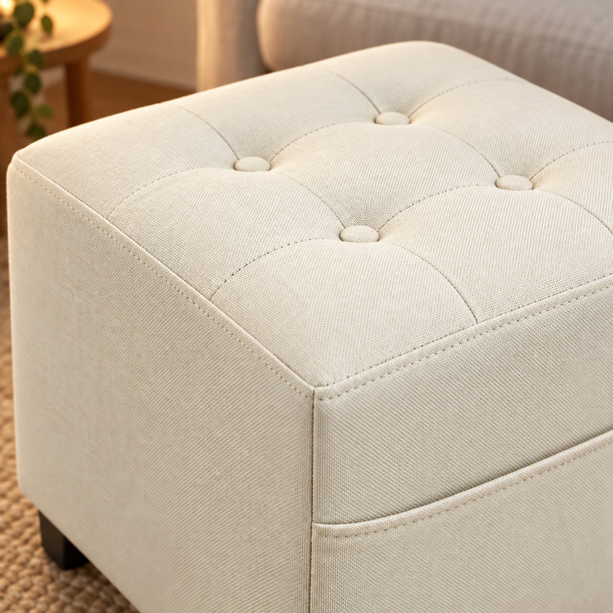 Repose-pieds cube aspect lin crème, poche latérale, gros plan sur la matière