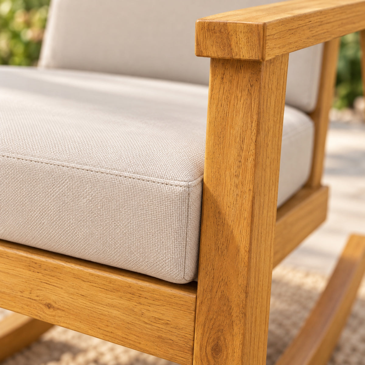 Rocking chair en acacia, dossier haut et coussins beiges, gros plan sur la matière