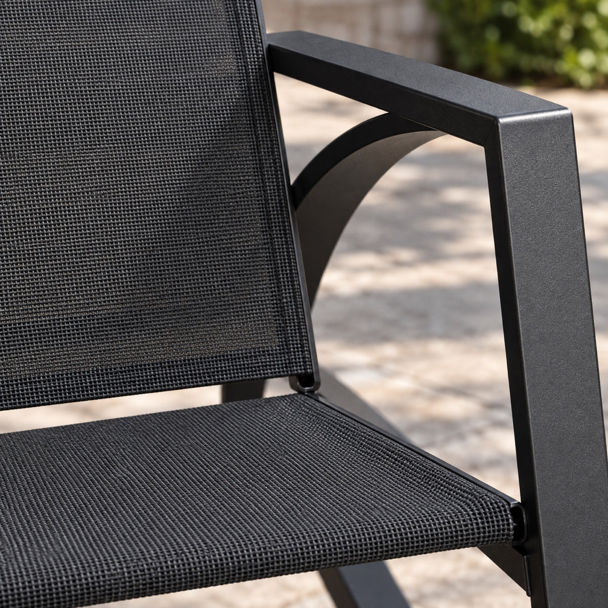 Rocking chair de jardin en métal noir et toile, gros plan sur la matière